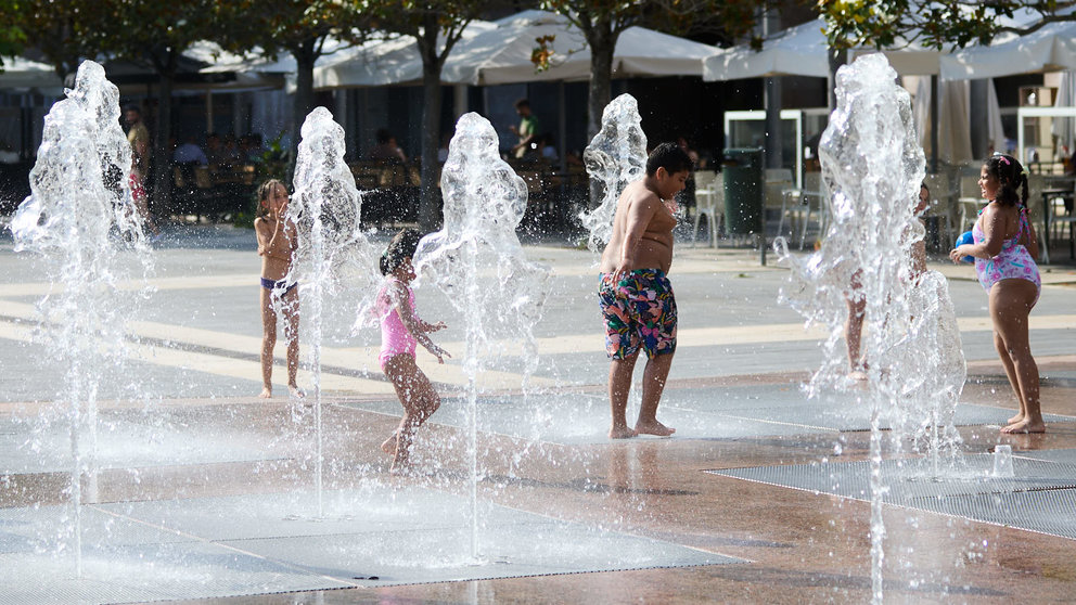 Unos niños juegan en la Fuente de los Chorros en el parque de Yamaguchi de Pamplona en el primer día de una nueva ola de calor de este verano. IÑIGO ALZUGARAY