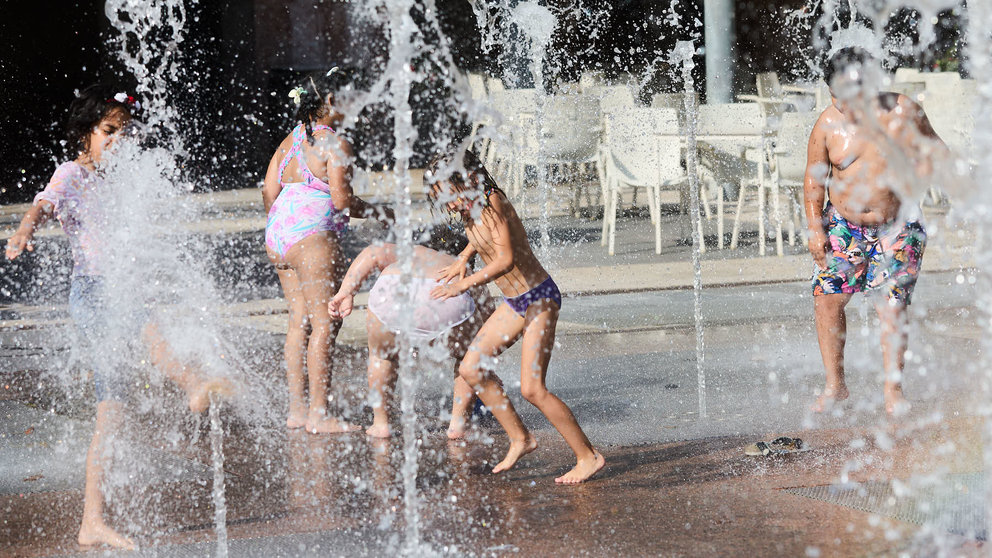 Unos niños juegan en la Fuente de los Chorros en el parque de Yamaguchi de Pamplona en el primer día de una nueva ola de calor de este verano. IÑIGO ALZUGARAY