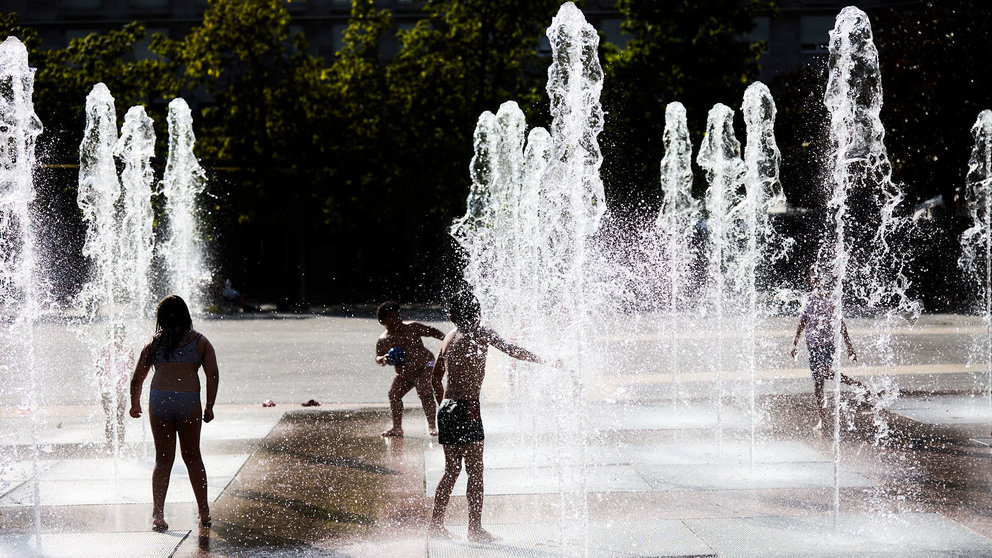 Unos niños juegan en la Fuente de los Chorros en el parque de Yamaguchi de Pamplona en el primer día de una nueva ola de calor de este verano. IÑIGO ALZUGARAY