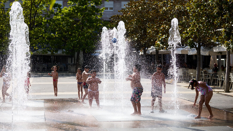 Unos niños juegan en la Fuente de los Chorros en el parque de Yamaguchi de Pamplona en el primer día de una nueva ola de calor de este verano. IÑIGO ALZUGARAY