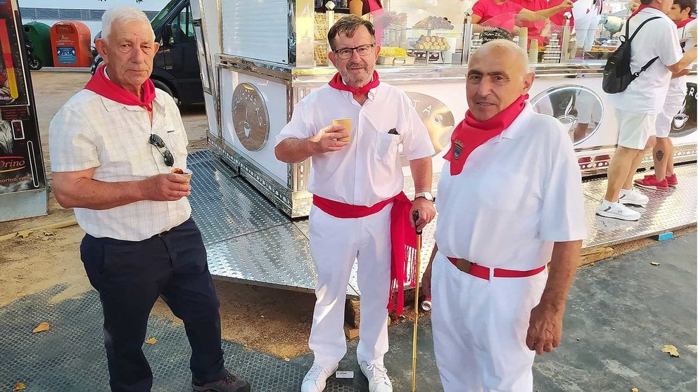 En el centro, Joaquín Lizar junto a dos amigos de su cuadrilla desayunando después del primer encierro de las fiestas de Santa Ana 2024 de Tudela. NAVARRA.COM