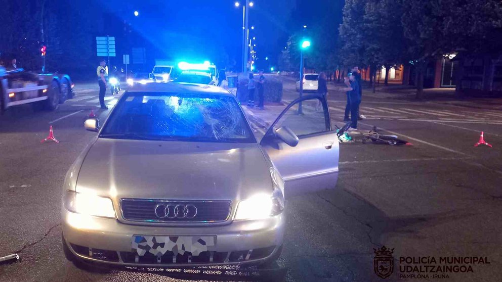 El vehículo que ha atropellado a los dos ciclistas y una de las bicicletas en el suelo. POLICÍA MUNICIPAL DE PAMPLONA