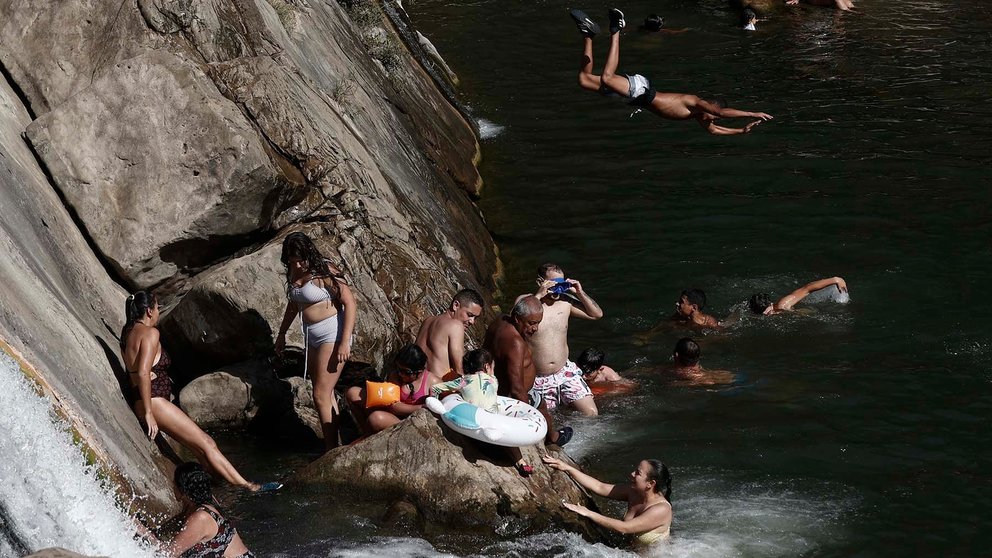 El cauce del rio Arga a su paso por la localidad de Huarte se llena de bañistas para intentar paliar con un buen baño el calor. EFE/ Jesus Diges