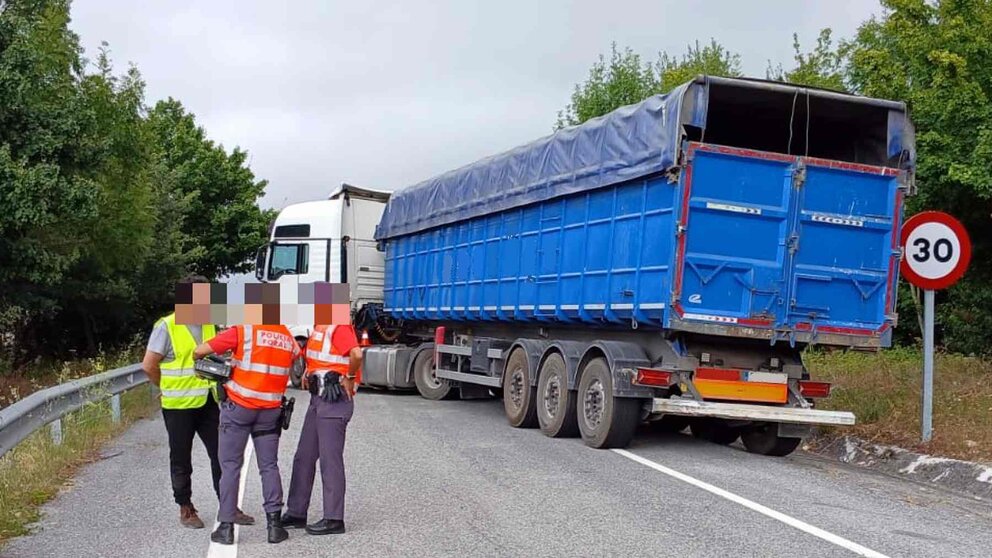 El camión bloqueando la carretera, el conductor del mismo, y las agentes a las que quiso "invitar a cerveza". POLICÍA FORAL