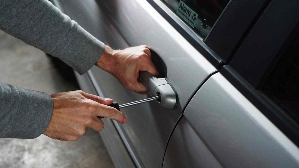 Un hombre tratando de forzar la cerradura de un coche con un destornillador. PIXABAI