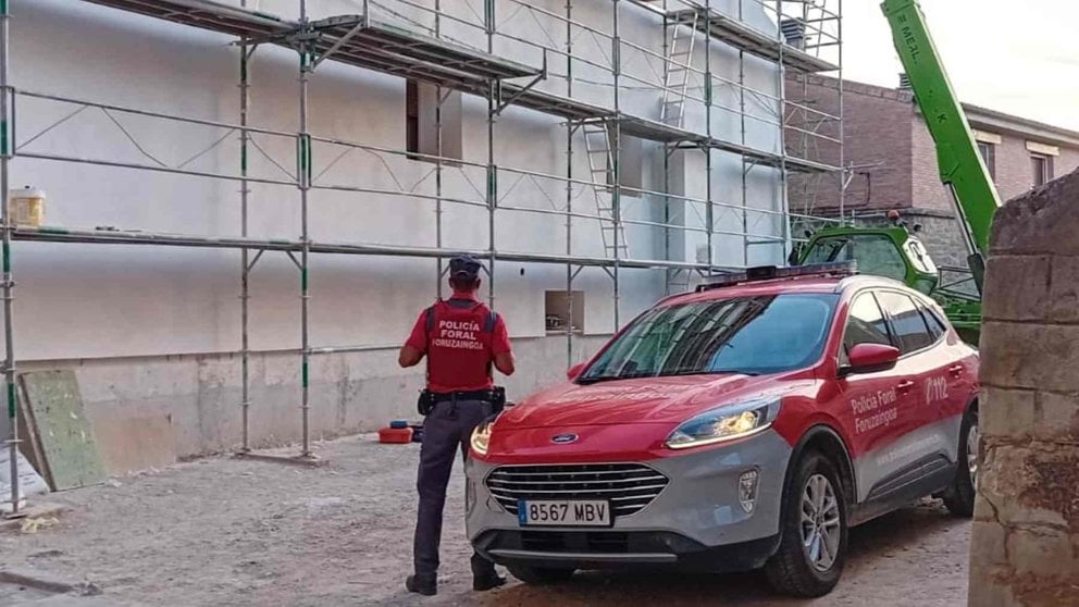 Un agente de la Policía Foral delante del andamio desde el que cayó el trabajador. POLICÍA FORAL