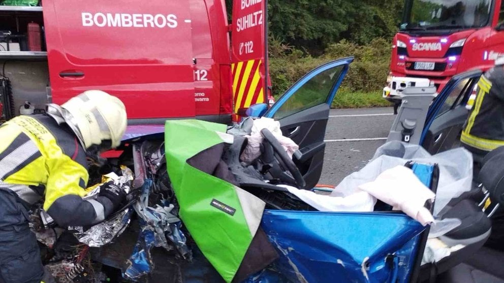 Los bomberos trabajando para sacar a la mujer herida de su coche. BOMBEROS DE NAVARRA