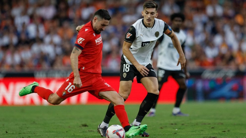 El centrocampista del Valencia CF Pepelu (d) pelea una posesión con el centrocampista del Osasuna Moi Gómez durante el encuentro correspondiente a la séptima jornada de LaLiga EA Sports que enfrenta al Valencia CF y al Osasuna en el estadio de Mestalla en Valencia, este martes. EFE/ Biel Aliño