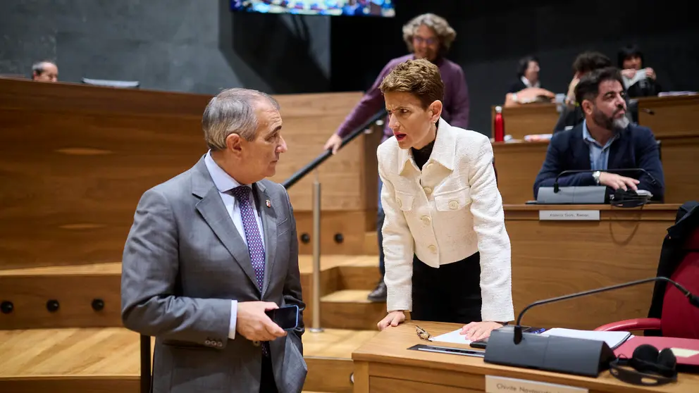 La presidenta Chivite habla con el consejero OScar Chivite minutos antes del comienzo del pleno del Parlamento. PABLO LASAOSA