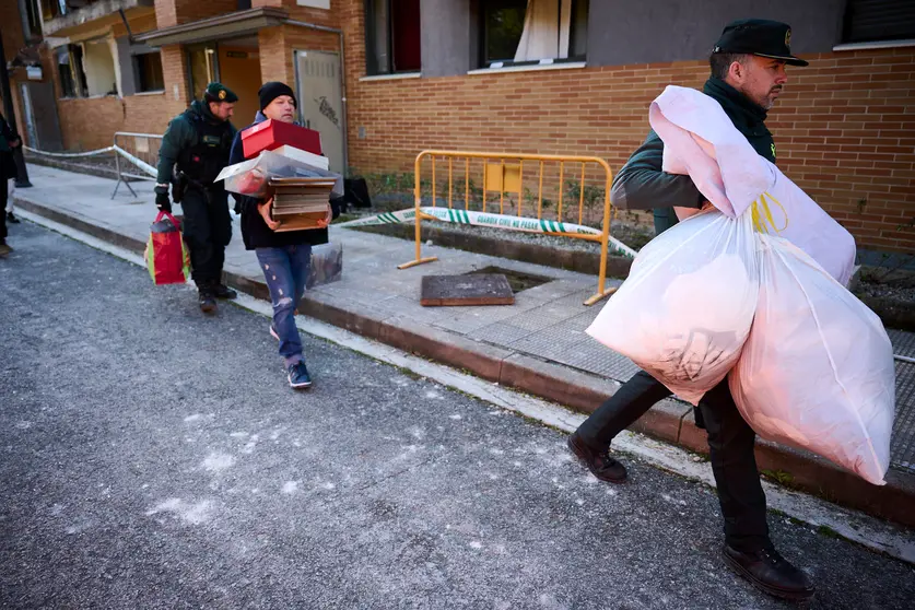 La Guardia Civil investiga las causas de la explosión de la vivienda de Noáin y ayuda a los vecinos para sacar las pertenencias de sus casas. PABLO LASAOSA