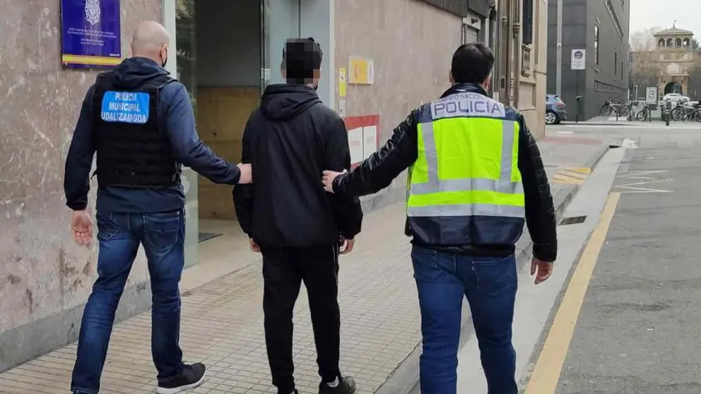 Un policía municipal de Pamplona y una gente de la Policía nacional conducen a uno de los detenidos a la comisaría. POLICÍA MUNICIPAL DE PAMPLONA