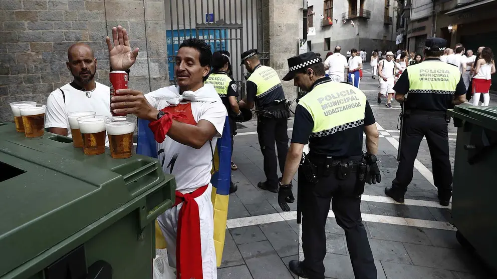 Unos jóvenes vacían el contenido de unas latas en vasos de plástico antes de acceder desde la Calle Nueva del casco Viejo hasta la Plaza del Ayuntamiento para el Chupìnazo. EFE/Jesús Diges / ARCHIVO