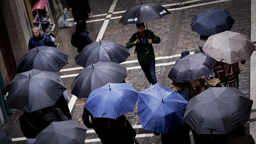 Un grupo de turistas se protegen de la lluvia con sus paraguas este sábado en Pamplona en una jornada en la que se esperan precipitaciones generalizadas y los puertos de Belagua y Larrau se cerrarán de forma preventiva desde las 18.00 horas, ante la previsión de alerta roja por nevadas en el Pirineo navarro por encima de los 1.200 metros, que pueden originar espesores superiores a los 40 centímetros, y será cuando el Gobierno de Navarra active el Plan de Emergencias por Nevadas en su fase de preemergencia. EFE/ Villar López