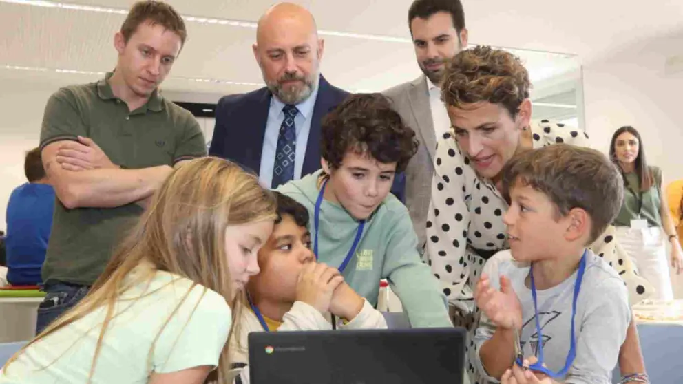 María Chivite junto a varios estudiantes de Primaria observando una pantalla de ordenador. AYUNTAMIENTO DE ZIZUR