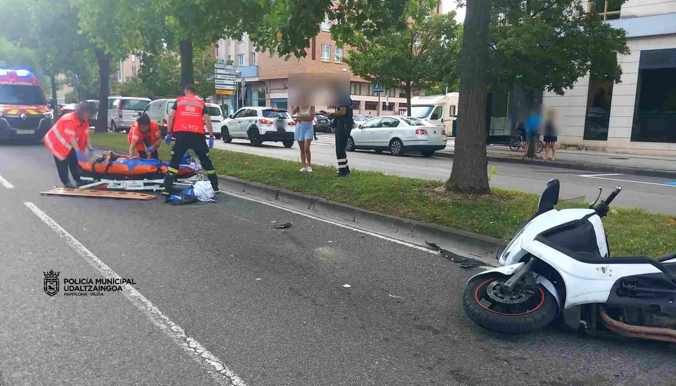 Sanitarios de Bomberos de Navarra atienden al motorista herido. POLICÍA MUNICIPAL DE PAMPLONA