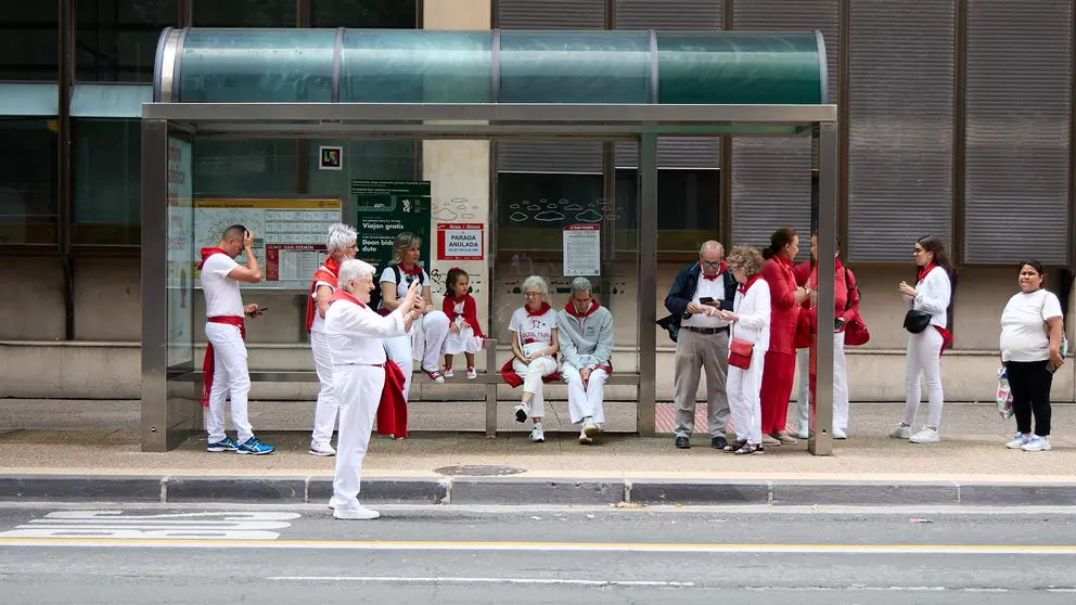 Unas personas esperan en una parada de autobús durante la huelga de villavesas en Sanfermines 2025. IÑIGO ALZUGARAY