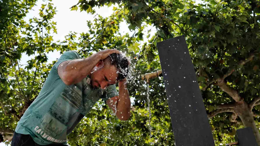 Una persona se refresca en una fuente de la Plaza del Castillo en un d&iacute;a de calor. EFE/ Jes&uacute;s Diges