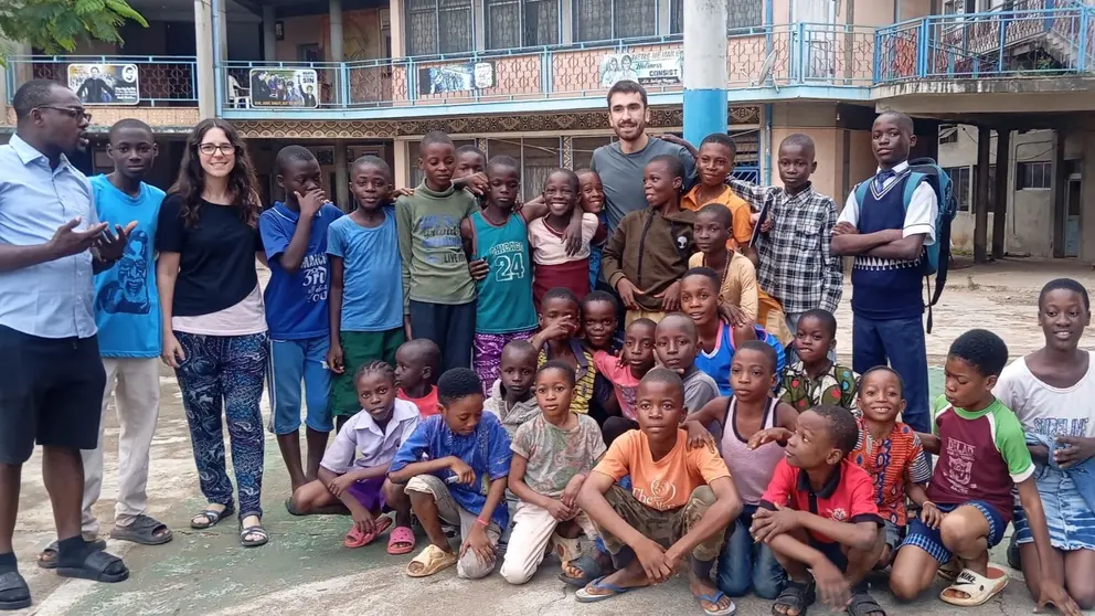 Iñigo Velaz con los niños y niñas del Child Protection Centre de los salesianos en Lagos (Nigeria) y la foto de Maite Piérola con un grupo de jóvenes mecánico en Cali (Colombia). CEDIDA