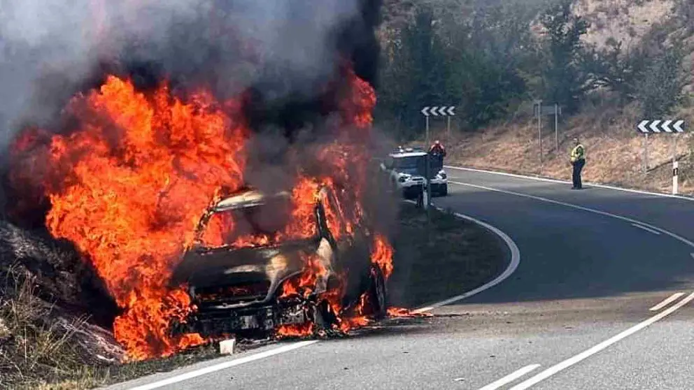 El coche en llamas en el arcén de la carretera en Murillo de Lónguida. GUARDIA CIVIL