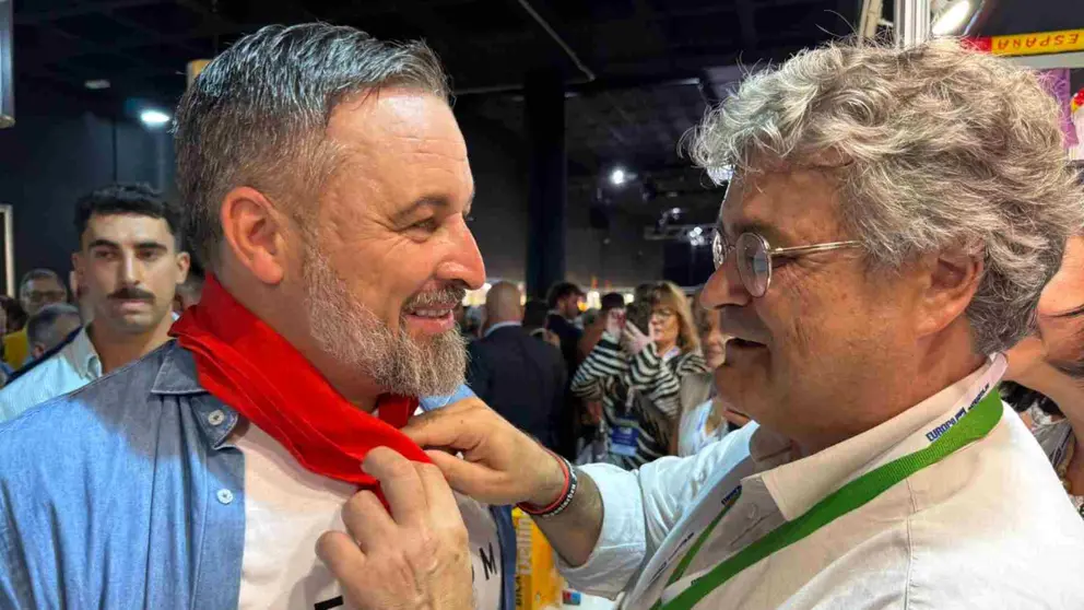 El presidente de Vox Navarra, José María García Elorz anuda el pañuelo de San Fermín a Santiago Abascal. VOX