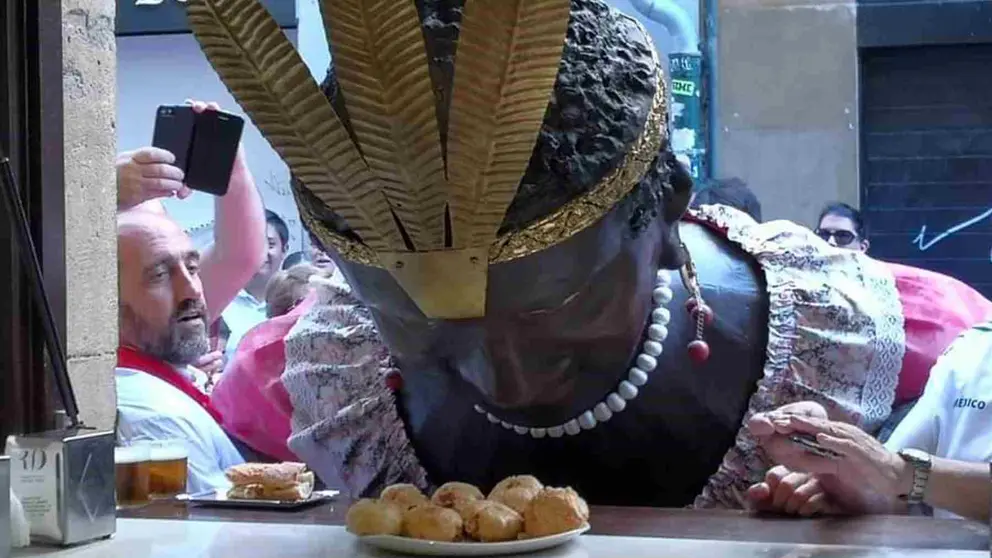 La Braulia, uno de los gigantes de Pamplona a punto de degustar uno de los famosos fritos de huevo de la Vermutería Río, en la calle Sam Nicolás, durante los pasados sanfermines. VERMUTERÍA RÍO