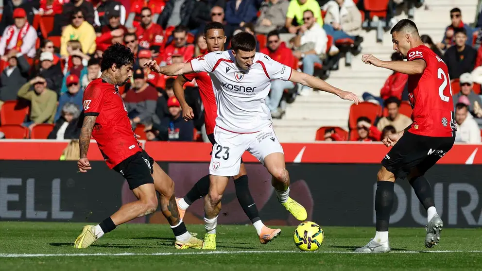El defensa del Osasuna Abel Bretones (c) disputa la posesi&oacute;n del bal&oacute;n con jugadores del RCD Mallorca durante el partido liguero entre el RCD Mallorca y el Osasuna celebrado en el estadio Son Moix, Palma de Mallorca, este s&aacute;bado. EFE/ Cati Cladera