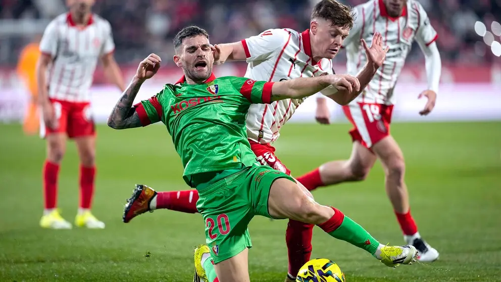 El defensa de Osasuna, Javi Gal&aacute;n (i), cae ante el delantero ucraniano del Girona, Vladyslav Vanat, durante el encuentro correspondiente a la jornada 19 de Laliga EA Sports que disputan hoy s&aacute;bado Girona y Osasuna en el estadio municipal de Montilivi, en la capital gerundense. EFE/David Borrat.