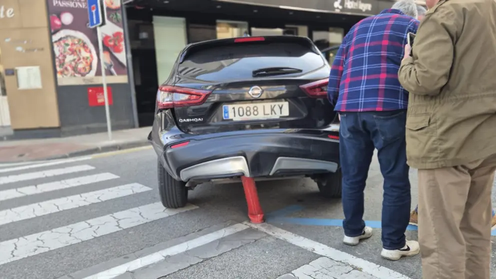 Un coche enganchado en un pivote en la calle de Leyre en Pamplona. CEDIDA