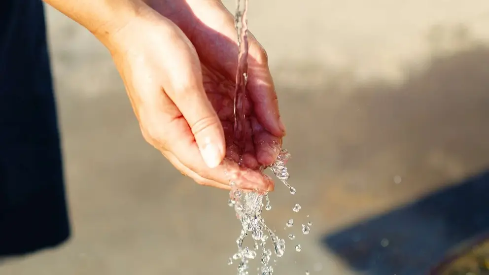 Unas manos recogen agua de una fuente. PIXABAI