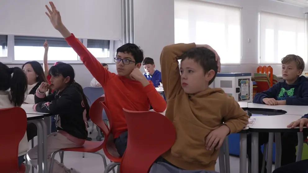 Escolares levantan la mano en el aula de un colegio. AYUNTAMIENTO DE PAMPLONA