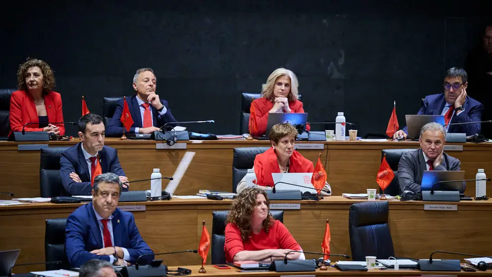 Parlamentarios de UPN colocan banderas de Navarra sobre la mesa durante el Pleno del Parlamento de Navarra. PABLO LASAOSA