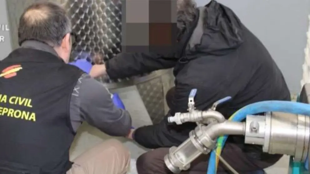Dos agentes inspeccionan el aceite fraudulento. GUARDIA CIVIL