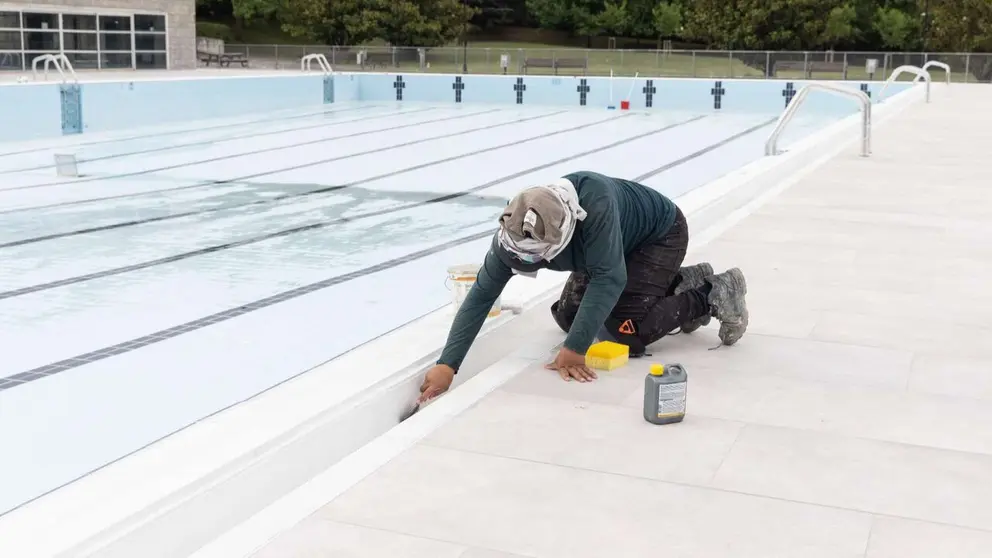 Un operario trabajando en la puesta a punto de las piscinas de Aranzadi para el verano. AYUNTAMIENTO DE PAMPLONA