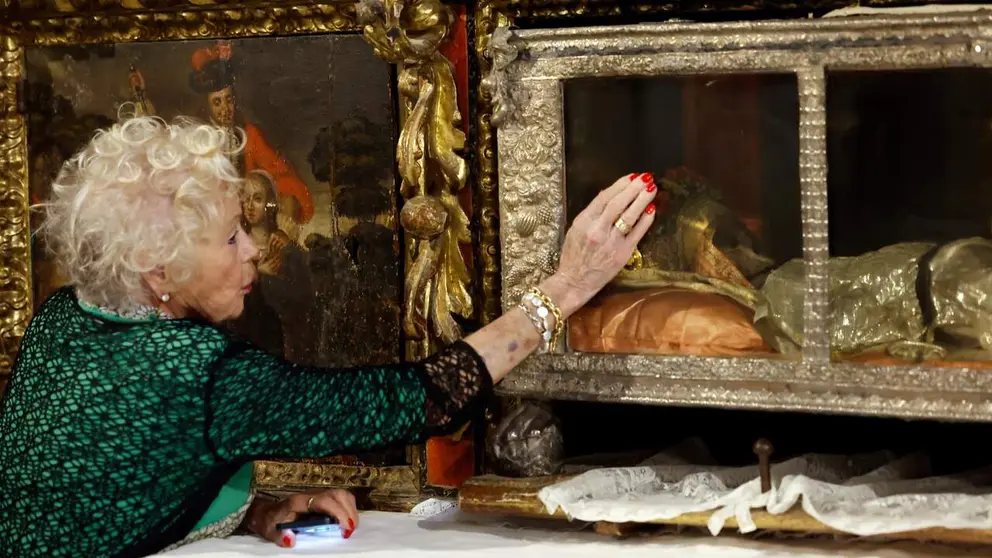 Una fiel acerca su mano al cristal del relicario que custodia el cr&aacute;neo de Santa Felicia de Aquitania. El relicario se encuentra junto a la pintura que narra su tr&aacute;gico martirio a manos de su hermano Guillermo en el siglo XI, refleja c&oacute;mo la devoci&oacute;n popular hacia esta santa sigue plenamente activa en la localidad navarra de Labiano, atrayendo a la gente del valle que buscan en sus restos una fuente de fe, protecci&oacute;n y salud. ​Hoy se la venera en Labiano (Navarra) como un s&iacute;mbolo de fe inquebrantable y perd&oacute;n, ya que su hermano se arrepinti&oacute; y tambi&eacute;n fue santificado. EFE/ Jes&uacute;s Diges
