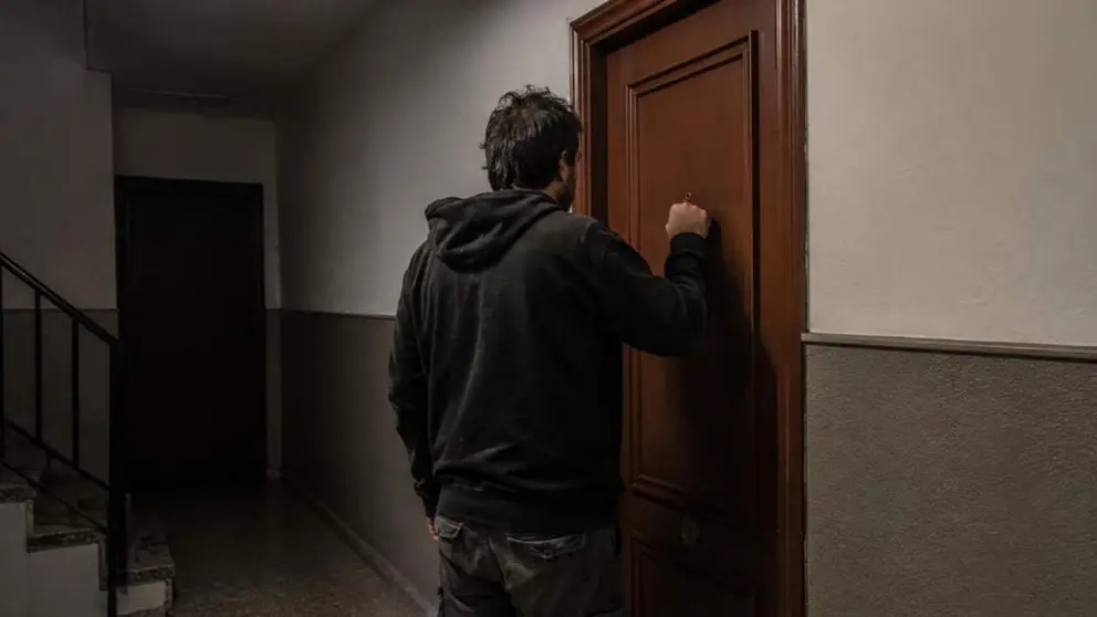 Un hombre llama a la puerta de un domicilio particular.