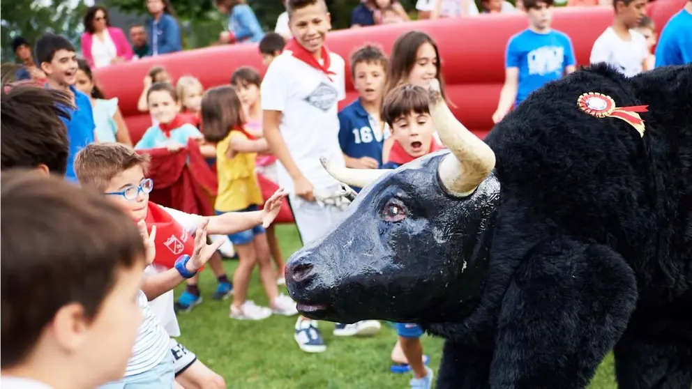 Los chavales disfrutan con el encierro del toro de cart&oacute;n . Foto Club de Tenis Pamplona.