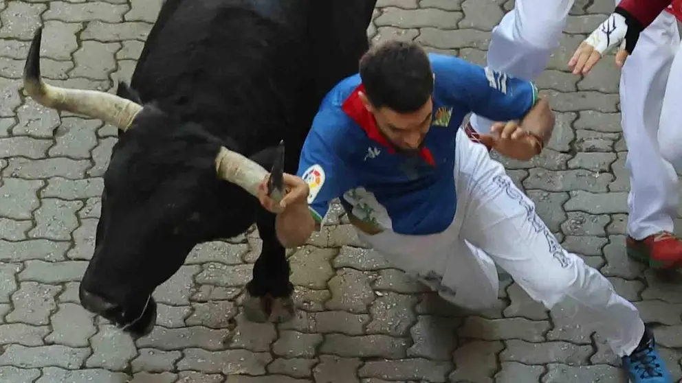 Un  mozo cae al paso de uno los toros de la ganader&iacute;a gaditana de Fuente Ymbro, en el tramo final que desemboca en el callej&oacute;n de la Plaza de Toros, durante el primer encierro de los Sanferimes 2026, este martes en Pamplona. EFE/ J.P. Urdiroz