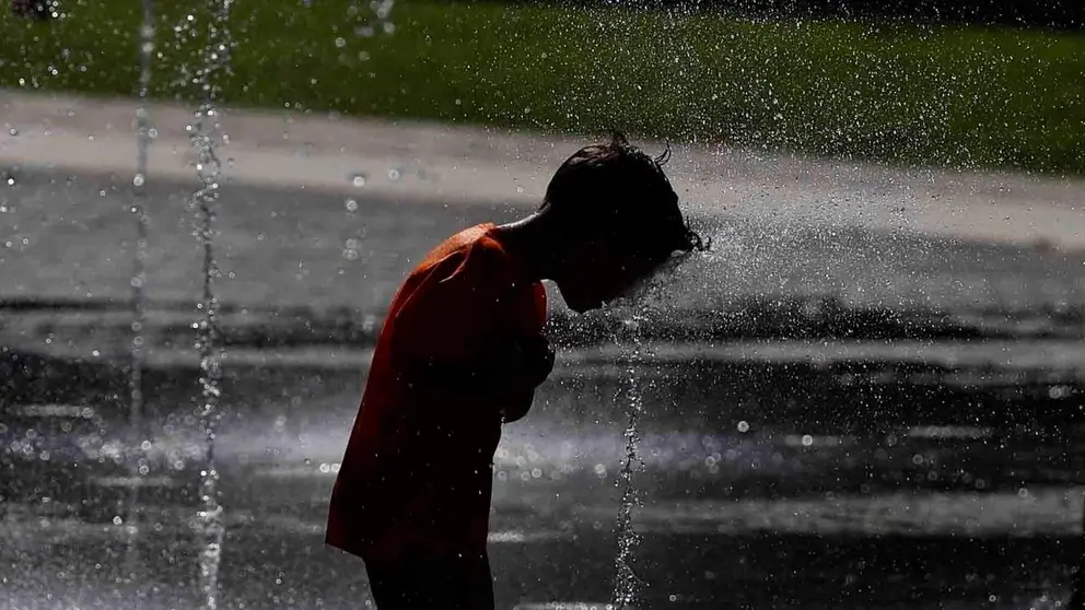 Un ni&ntilde;o se refresca en unos chorros de agua. EFE/ Rodrigo Jim&eacute;nez