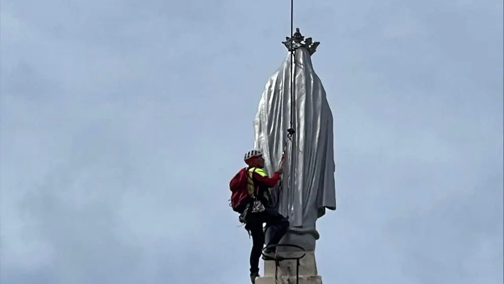 Un bombero interviene por el peligro de ca&iacute;da de la mano de la Virgen de la Milagrosa de Pamplona. BOMBEROS DE NAVARRA