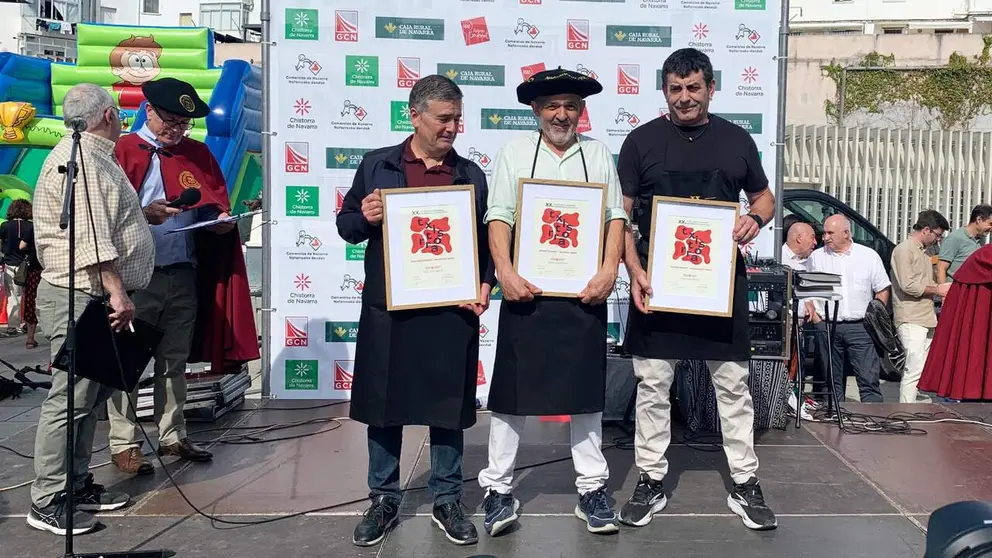 Jos&eacute; Ignacio Zuazu en el centro de los tres premiados en la fiesta de la chistorra en Pamplona. Navarra.com