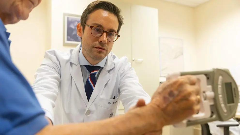 El Dr. Miguel Germ&aacute;n Borda realiza la prueba de sarcopenia con el dinam&oacute;metro de mano a uno de sus pacientes. CL&Iacute;NICA UNIVERSIDAD DE NAVARRA
