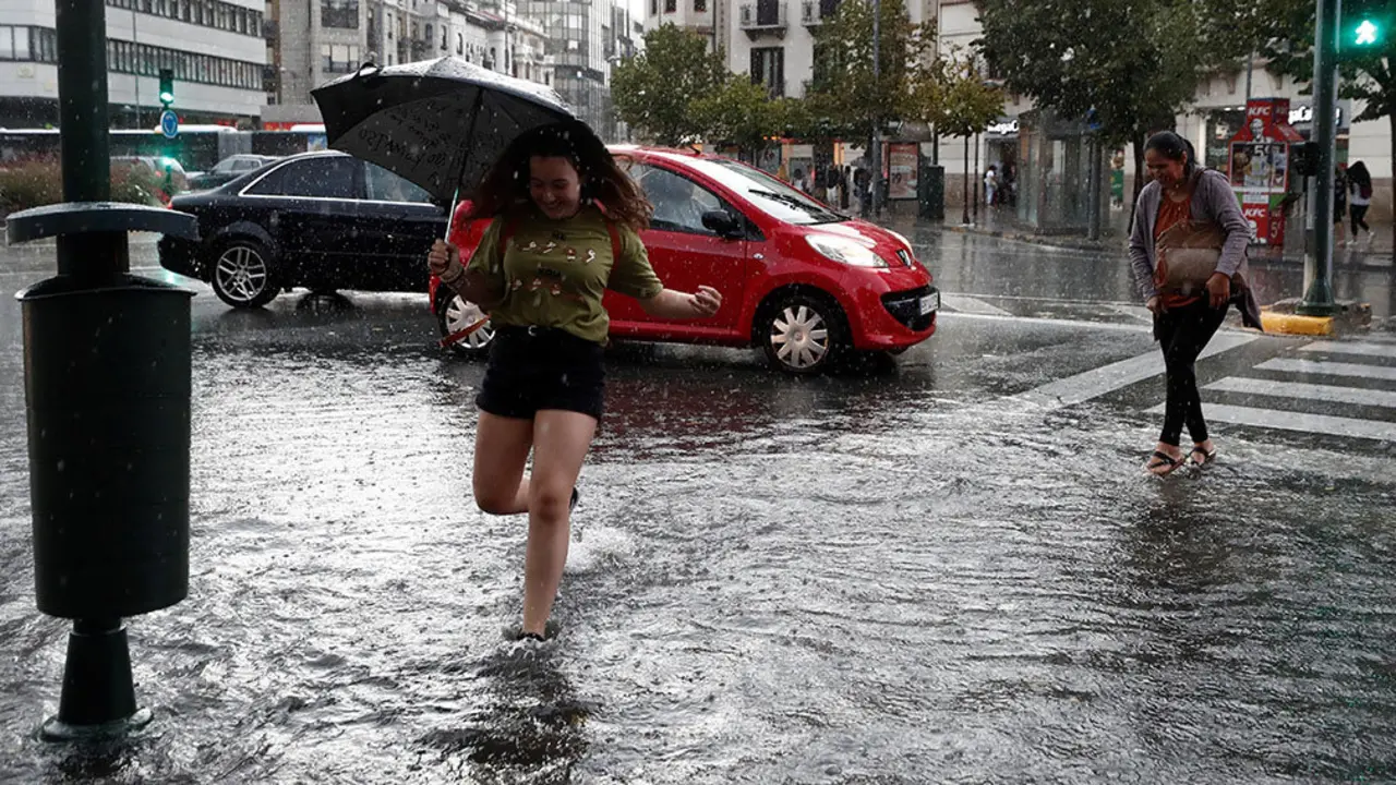 GRAFCAV8055. PAMPLONA (NAVARRA), 18/09/2019.- Varias personas cruzan la Avenida Baja Navarra que se encuentra inundada de agua tras la fuerte tormenta de esta tarde que ha ocasionado numerosas balsas en las carreteras y donde los bomberos han realizado numerosas salidas para achicar agua en Pamplona. EFE/ Jes&uacute;s Diges