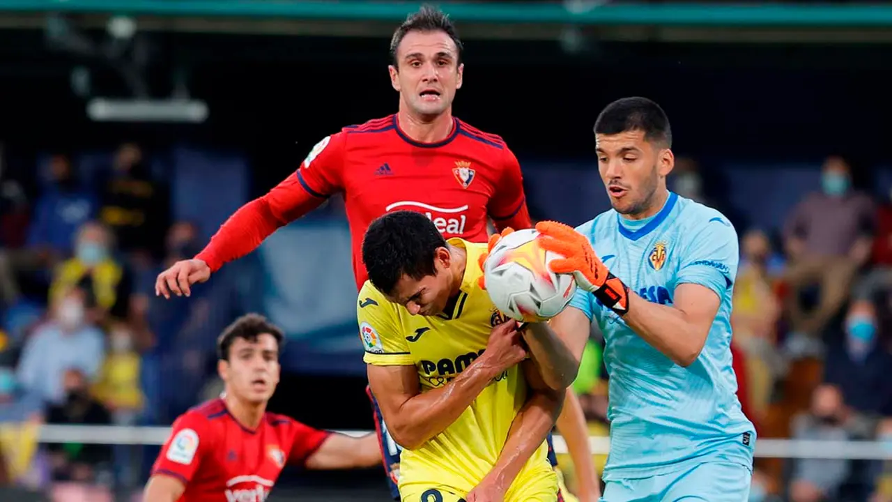 El guardameta argentino del Villarreal, Gerónimo Rulli (d), captura el balón ante su compañero, el argelino Aissa Mandi (c) y el delantero de Osasuna, Kike García, durante el encuentro correspondiente a la novena jornada de primera división que disputan hoy domingo en el estadio de La Cerámica, en la localidad castellonense. EFE/Doménech Castelló.