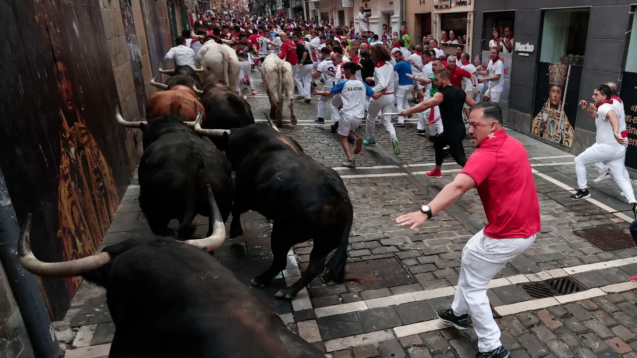 Los toros de la ganadería de Fuente Ymbro pasan por la curva de Mercaderes y enfilan la calle de la Estafeta en el cuarto encierro de los Sanfermines este miércoles, en Pamplona. EFEJesús Diges