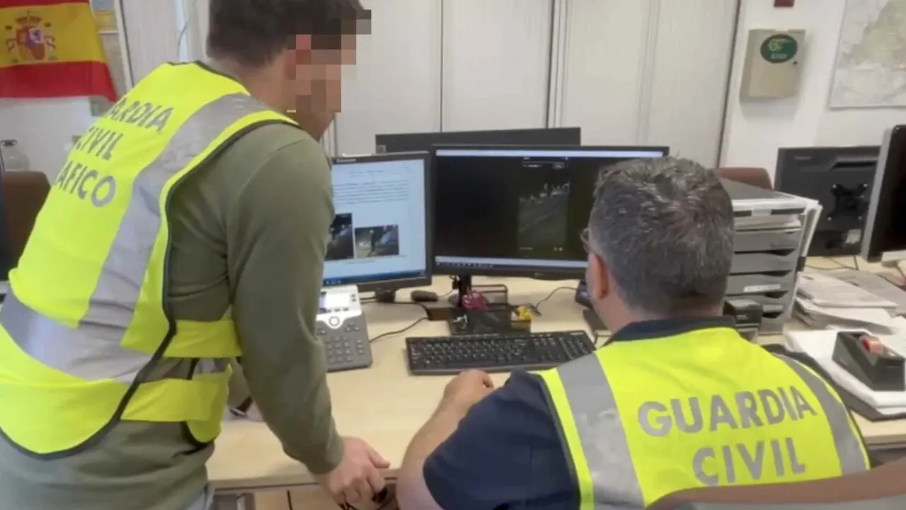 Dos guardias civiles investigan las im&aacute;genes de las carreras ilegales. GUARDIA CIVIL