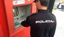 Un policía nacional revisa un cajero automático