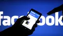 Una persona sujeta un móvil con la aplicación de Facebook abierta.