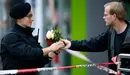 Un hombre entrega unas flores a un policía junto a la zona de Múnich donde ocurrió el tiroteo. REUTERS