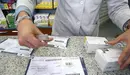 Un farmacéutico trabaja con varias recetas en papel Imagen de archivo