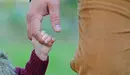 Un padre lleva de la mano a su hija a una escuela infantil.